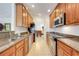 Galley kitchen features granite countertops and light wood cabinets, providing ample storage space at 8374 Quimby Cir # 8374, Davenport, FL 33896