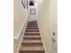 Carpeted staircase leading to the upper level featuring a white handrail and light yellow walls at 8374 Quimby Cir # 8374, Davenport, FL 33896