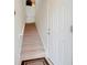 Carpeted staircase leading to the upper level of the home, featuring a white handrail and a white front door at 8374 Quimby Cir # 8374, Davenport, FL 33896
