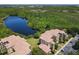 Aerial view of the community, showcasing the buildings, the lake, and lush landscaping at 8774 Worldquest Blvd # 7503, Orlando, FL 32821