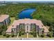 Aerial view of the condominium complex with a lake and lush surroundings at 8774 Worldquest Blvd # 7503, Orlando, FL 32821