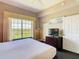 Bright bedroom featuring a large window with scenic views, soft lighting, and comfortable furnishings, door to the hallway at 8774 Worldquest Blvd # 7503, Orlando, FL 32821