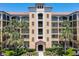 Multi-story condominium building featuring a tile roof and tropical landscaping at 8774 Worldquest Blvd # 7503, Orlando, FL 32821