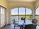Serene screened patio with comfortable seating, an arched enclosure, and a picturesque view of the tranquil lake scenery at 8774 Worldquest Blvd # 7503, Orlando, FL 32821