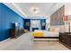 Bright bedroom with blue accent wall, tray ceiling, and comfortable furnishings offers a cozy retreat at 8943 Amelia Downs Trl, Kissimmee, FL 34747