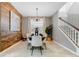 Elegant dining room featuring modern lighting, a decorative wood wall, and staircase to the second floor at 8943 Amelia Downs Trl, Kissimmee, FL 34747