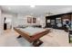 Spacious game room with a pool table, dark accent wall, and arcade games provides entertainment space at 8943 Amelia Downs Trl, Kissimmee, FL 34747
