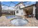 Relaxing screened-in pool and jacuzzi, with lounge chairs on the brick patio and open access to the home at 8943 Amelia Downs Trl, Kissimmee, FL 34747