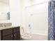 Bathroom featuring a granite vanity and sink combo next to a bathtub with a blue shower curtain at 9016 Pyrus St, Kissimmee, FL 34747