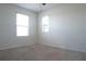 This bedroom features neutral carpets, two large windows, and many electrical outlets at 9016 Pyrus St, Kissimmee, FL 34747