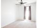 A bright bedroom featuring neutral carpet, a modern ceiling fan and a window with patterned curtains at 9016 Pyrus St, Kissimmee, FL 34747