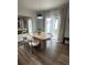 Dining area featuring a modern table with four chairs, hardwood floors and sliding door to backyard at 9016 Pyrus St, Kissimmee, FL 34747