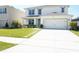 Charming two-story home featuring a well-manicured lawn and a convenient two-car garage at 9016 Pyrus St, Kissimmee, FL 34747