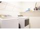 Bright laundry room features new washer and dryer, with wire rack storage overhead at 9016 Pyrus St, Kissimmee, FL 34747
