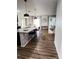 Open-concept living space with wood floors, modern kitchen with bar seating, and a cozy seating area at 9016 Pyrus St, Kissimmee, FL 34747
