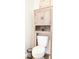 Cozy bathroom features a rustic cabinet, white toilet, and a small trash can, creating a functional space at 9016 Pyrus St, Kissimmee, FL 34747