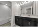 Bright bathroom featuring a double vanity with a modern light fixture, a bathtub with white tiled walls, and tile floors at 9056 Pinch Shot Dr, Winter Garden, FL 34787