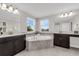 Bathroom showcasing a large tub, dual vanities, and modern lighting at 9056 Pinch Shot Dr, Winter Garden, FL 34787