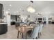 Dining area next to an open kitchen featuring an elegant chandelier and modern seating, perfect for entertaining at 9056 Pinch Shot Dr, Winter Garden, FL 34787