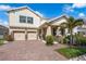 Charming two-story home featuring a paver driveway, attached two-car garage, and nicely landscaped front yard at 9056 Pinch Shot Dr, Winter Garden, FL 34787