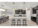 Open kitchen with dark cabinets, stainless steel appliances, island seating and adjacent dining area at 9056 Pinch Shot Dr, Winter Garden, FL 34787