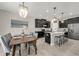 Open kitchen with an island, modern black cabinets, stainless steel appliances, and adjacent dining area at 9056 Pinch Shot Dr, Winter Garden, FL 34787