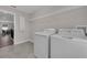 Functional laundry room with washer, dryer, overhead shelving, and tile flooring for easy maintenance at 9056 Pinch Shot Dr, Winter Garden, FL 34787