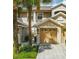 Inviting townhome exterior featuring a one car garage, tan stucco and well-maintained landscaping at 9435 Myrtle Creek Ln # 304, Orlando, FL 32832