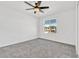 Carpeted bedroom featuring a ceiling fan and large window at 1003 Sugarwood St, Davenport, FL 33837