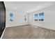 Bright living room with wood laminate flooring, three large windows, and recessed lighting at 1003 Sugarwood St, Davenport, FL 33837