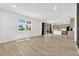 Spacious living room with wood laminate flooring, slider to screened porch, and view to the kitchen at 1003 Sugarwood St, Davenport, FL 33837