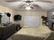 A cozy bedroom featuring a ceiling fan, window with blinds, and dark dresser at 1019 Lake Berkley Dr, Kissimmee, FL 34746
