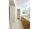 Bathroom featuring dual sinks, granite countertops, and access to the walk-in closet at 1102 Peregrine St, Groveland, FL 34736
