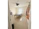 A cozy bedroom featuring a light-colored wall, natural lighting, and tile floors at 1102 Peregrine St, Groveland, FL 34736