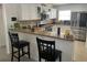 An open kitchen with sleek stainless steel appliances, granite countertops, and bar seating at 1102 Peregrine St, Groveland, FL 34736