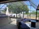 Relaxing screened lanai with an outdoor kitchen and comfortable seating arrangements at 1102 Peregrine St, Groveland, FL 34736