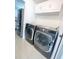 Modern laundry room featuring new front loading washer and dryer next to stainless refrigerator at 1102 Peregrine St, Groveland, FL 34736