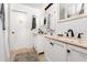 Bathroom featuring dual sinks with peach marble tops, white vanities, and bronze fixtures at 1190 Sandestin Way, Orlando, FL 32824