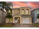 Inviting two-story home with a well-manicured lawn and a charming front porch with beautiful sky backdrop at 1190 Sandestin Way, Orlando, FL 32824