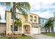 Inviting two-story home with a well-manicured lawn and a charming front porch with an attached two-car garage at 1190 Sandestin Way, Orlando, FL 32824
