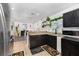 Open-concept kitchen featuring black cabinets, tiled floor, and view of adjacent dining area at 1190 Sandestin Way, Orlando, FL 32824