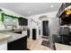 Well-lit kitchen with black cabinets, tan countertops, and stainless steel appliances at 1190 Sandestin Way, Orlando, FL 32824
