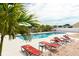 Community pool area with brick pavers, lounge chairs, and palm trees for relaxed living at 1190 Sandestin Way, Orlando, FL 32824