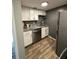 Compact kitchen featuring white cabinets, stainless steel appliances, and granite countertops at 131 Water Front Way # 220, Altamonte Springs, FL 32701