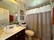 Standard bathroom features a vanity with a sink, toilet, shower with curtain, and decor at 14963 Braywood Trl, Orlando, FL 32824