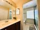 Bathroom featuring a vanity with sink, multiple mirrors, and an adjacent toilet and shower area at 14963 Braywood Trl, Orlando, FL 32824