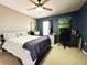 Bedroom with a bed and modern desk, well-lit by a ceiling fan, and decorated with personalized wall art at 14963 Braywood Trl, Orlando, FL 32824