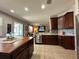 Well-appointed kitchen with stainless steel appliances, dark cabinets, tile floors, and a center island at 14963 Braywood Trl, Orlando, FL 32824
