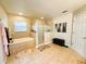 Bright bathroom featuring double sinks, a separate tub and shower, and neutral tile flooring at 14963 Braywood Trl, Orlando, FL 32824