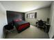 Bedroom featuring a dark accent wall, carpeted floors, and a functional desk area at 1695 Lee Rd # E215, Winter Park, FL 32789